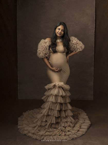A full-length view of the ruffled gown, showcasing its magnificent train and the queenly presence it gives the mother-to-be.