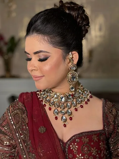 A beautiful side profile of a bride, showcasing her messy bun, the heavy kundan necklace, and the perfectly draped dupatta.
