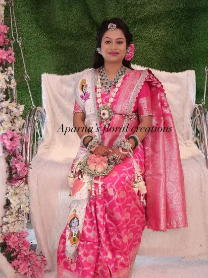 This mom-to-be is wearing a custom jewellery set that includes a unique floral sash with a painted Krishna motif for her Dohale Jevan.