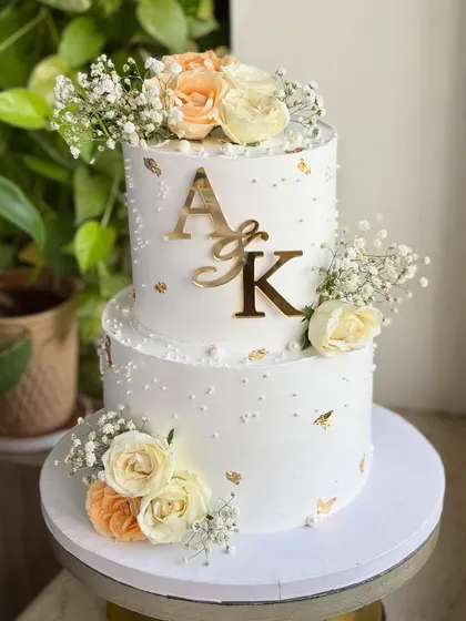 When love is golden. ✨ I designed this timeless two-tier engagement cake with delicate fresh florals, soft pearls, and hints of gold leaf. It’s perfect for whispering “she said yes” in the most graceful way.