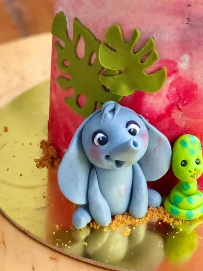 A detailed shot of the cute fondant elephant and snake at the base of the jungle cake.