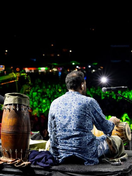A view from behind the percussionist, looking out at the massive, glowing audience at Jazz Al Parque. It's a powerful reminder of the connection we build with every person in the crowd.
