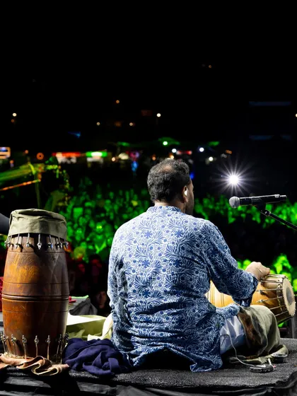 A view from behind the percussionist, looking out at the massive, glowing audience at Jazz Al Parque. It's a powerful reminder of the connection we build with every person in the crowd.