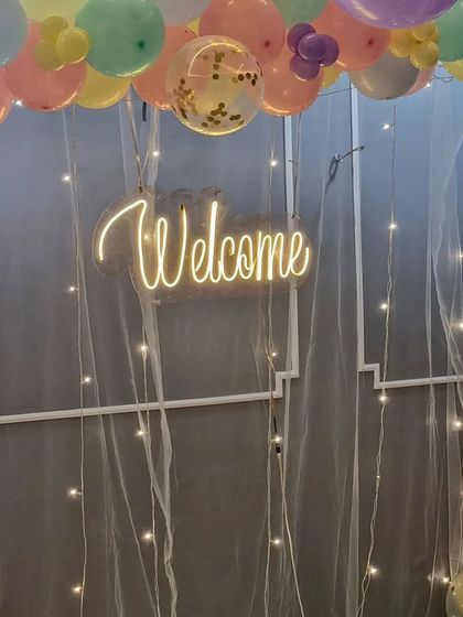 Detail shot of the "Welcome" neon sign, showing how it creates a warm and inviting glow for the celebration.