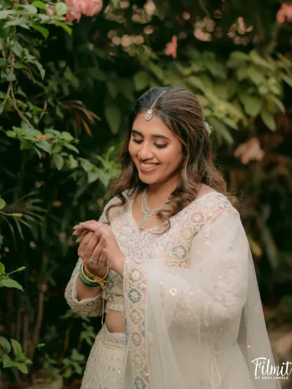 A candid moment of the bride-to-be. The soft waves in her hair and the dewy finish on her skin create a look that is both effortless and perfectly polished for her engagement photos.