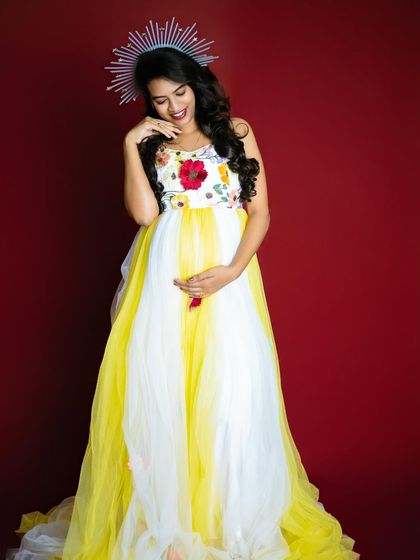 Adding a touch of modern flair with a sunburst crown, this shot combines the summery gown with a unique accessory for a stylish maternity portrait.
