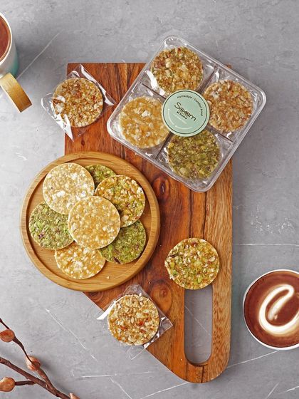 An assortment of my healthy chikkis on a wooden board. This image shows the variety I offer, from peanut to pistachio, ensuring there's a crunchy treat for everyone.