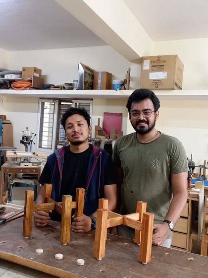 Here are Ram and Gyanesh on day two with the matching planter stands they built and finished with a dark stain. They learned how to use a table saw for the half-lap joints.