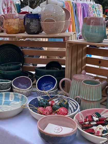 A wide shot of my stall at a bustling outdoor market. I love creating a diverse display with a mix of mugs, bowls, teapots, and festive decor to show the full range of my work.