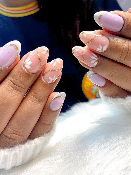 When nails tell a story of beauty and grace. This lovely set features a soft lavender base with delicate white flowers and sparkling gold glitter lines.