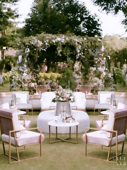 A circular lounge setup at the 'Romantic Garden' wedding in Bali. The combination of modern pink chairs and a central floral arrangement created an elegant and inviting space for guests.