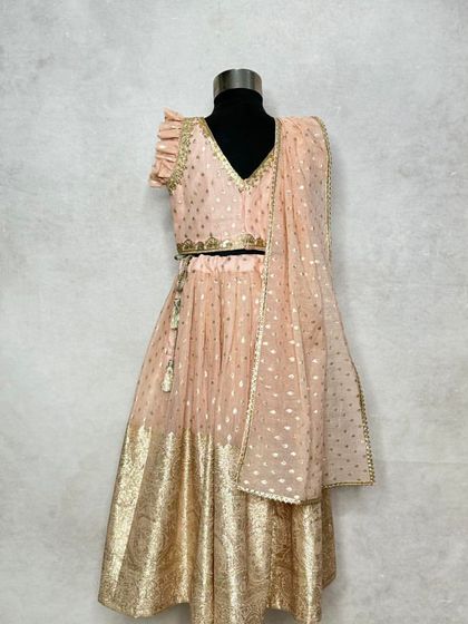 The periwinkle lehenga on a mannequin, showing the full outfit with its ruffled choli and matching dupatta.