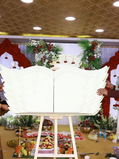 The moment of the name reveal, with the parents proudly presenting their baby's name on a custom-designed angel-wing plaque.