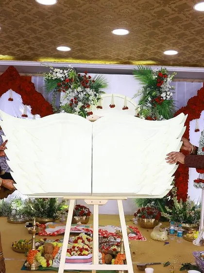 The moment of the name reveal, with the parents proudly presenting their baby's name on a custom-designed angel-wing plaque.