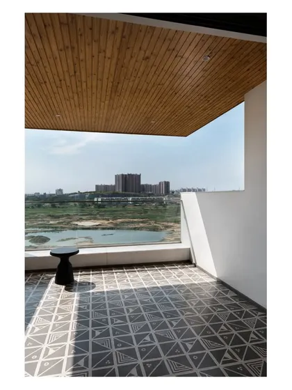 The living room opens to a large balcony with patterned cement tiles and a pine wood ceiling, offering expansive views of Hulimavu Lake.