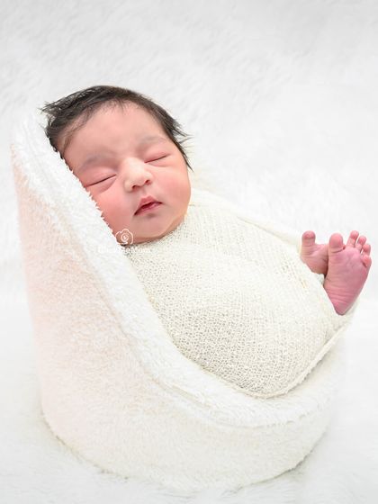 Simplicity at its best. A baby wrapped in a textured white swaddle on a pure white background creates a timeless and angelic portrait.