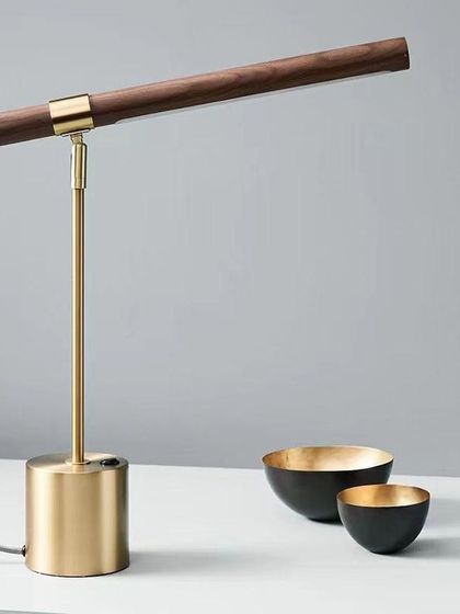 We designed this desk lamp for both style and function. The combination of a metal base, an antique brass stem, and a rotatable wood light bar makes it a personalized and elegant reading lamp for any study or office.