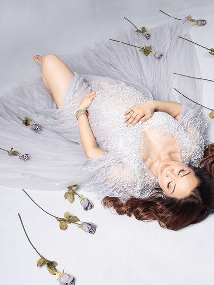 Simplicity is key. This artistic, top-down shot with a sheer white drape and scattered roses is beautifully minimalist and serene.