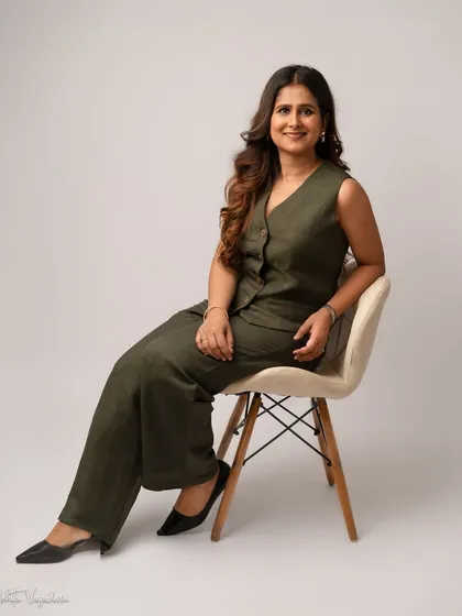 A smart, coordinated outfit can elevate a business portrait. This seated pose in an olive co-ord set looks effortlessly chic and professional, perfect for a modern entrepreneur.