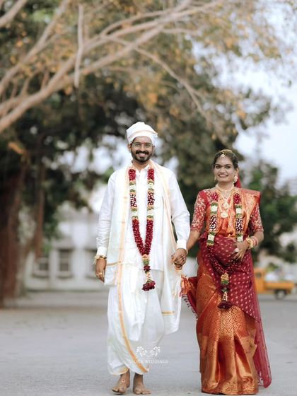 A happy portrait of the couple walking towards the camera, hand-in-hand, after their wedding.