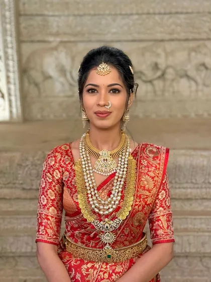 A classic portrait showcasing the timeless beauty of a traditional red saree look.