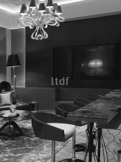 In this luxurious living room, handed over 15 years ago, an exquisite bar stands as a focal point. Bathed in the soft glow of a magnificent chandelier, the space is elevated by its intricate design, blending opulence with functionality to create a captivating ambiance.