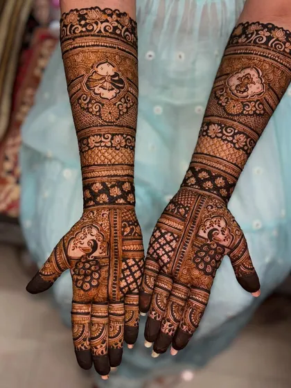 A stunning bridal design with peacocks and lotus motifs. The dark, rich application of the henna paste promises a beautiful and long-lasting stain for the wedding festivities.