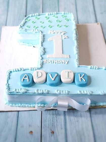 A number "1" shaped cake for a first birthday. This is a great way to celebrate a milestone, personalized with the baby's name in fondant blocks.