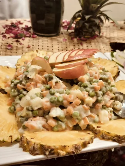 A close-up of my Russian salad, showing the creamy texture and fresh vegetables, artfully presented on a pineapple ring platter.