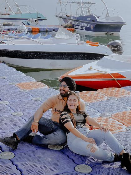 A happy, relaxed moment on a dock in Rishikesh. The background of boats and water adds a casual, vacation-like feel to this pre-wedding shoot.