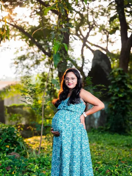 Bathed in the warm glow of the sun, this mom-to-be looks absolutely radiant in a simple blue dress, surrounded by nature.