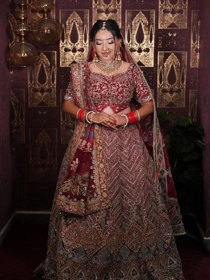 A full-length shot showcasing the grandeur of this maroon bridal lehenga. It's a perfect choice for a bride who wants a royal and elegant look.