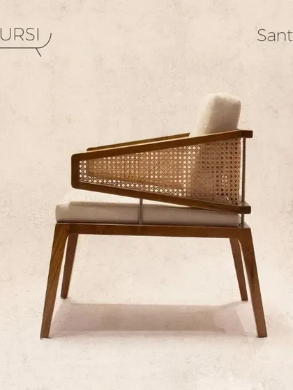 The 'Santoor' chair is both comfortable and classy. Its unique angular armrests with rattan panels and plush cushions make it a versatile piece for a library or as a statement chair in a living room.