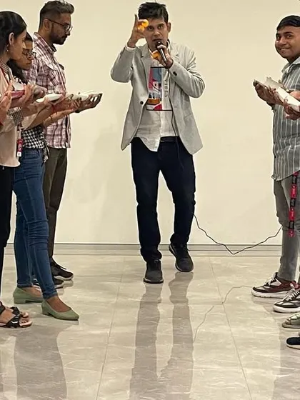 Leading a team building exercise where concentration is key. I am explaining the rules before the fun begins, ensuring everyone is on the same page for this ball-balancing challenge.