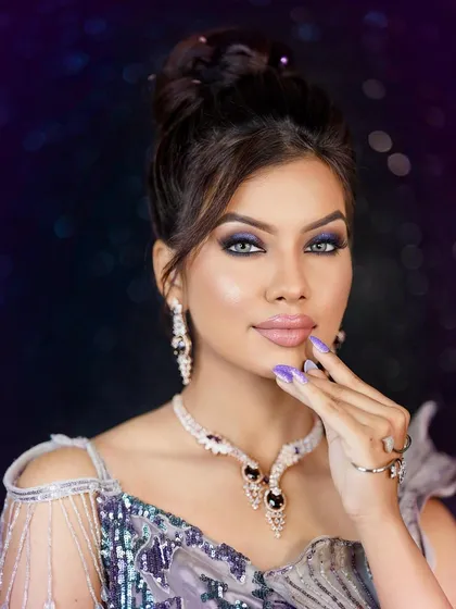 A bold and glamorous look perfect for a cocktail party or reception. The model wears a stunning diamond and sapphire set against a sequined gown, with dramatic smokey eye makeup.