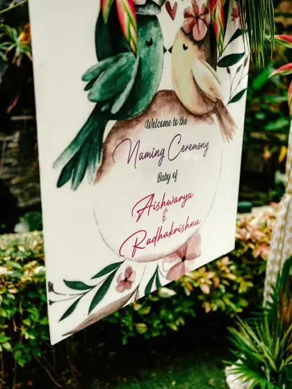 A close-up of the beautifully designed welcome sign for the naming ceremony, featuring watercolor lovebirds.