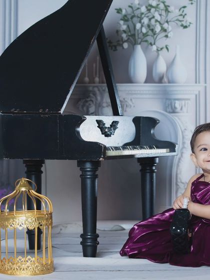 This little musician is ready for her piano recital, dressed in a beautiful velvet gown.