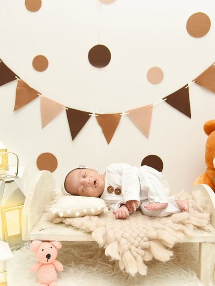 Another angle of the teddy bear theme, showing the baby sleeping peacefully under a banner of brown and beige flags.