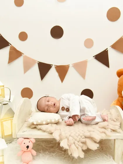 Another angle of the teddy bear theme, showing the baby sleeping peacefully under a banner of brown and beige flags.