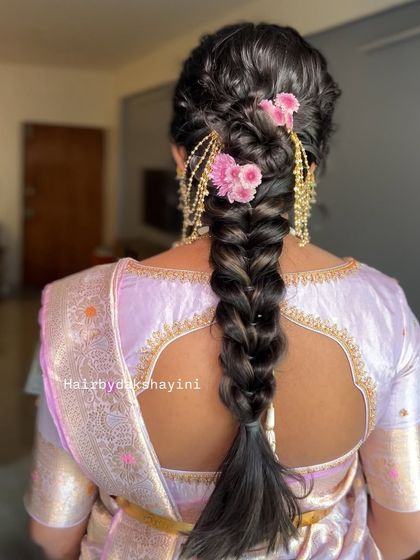 A lovely textured braid adorned with pink flowers and traditional gold earring chains (maatal) for a unique fusion look.