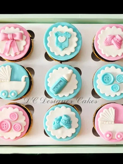 These delicate baby shower cupcakes are a popular choice for welcoming a new arrival. Each chocolate cupcake is topped with intricate, handmade fondant designs like baby carriages, booties, and bows in a classic pink and blue theme.