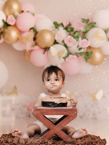 A beautiful butterfly-themed cake smash for a first birthday. The soft pink and gold balloon arch creates a magical and delicate backdrop in our studio.