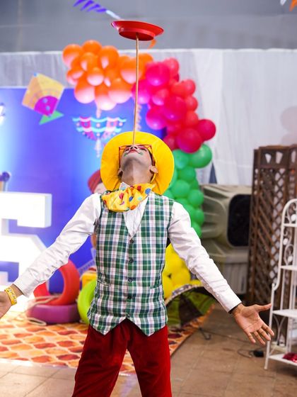 Another skilled circus performer demonstrating incredible balance by spinning a plate on a stick held in his mouth.