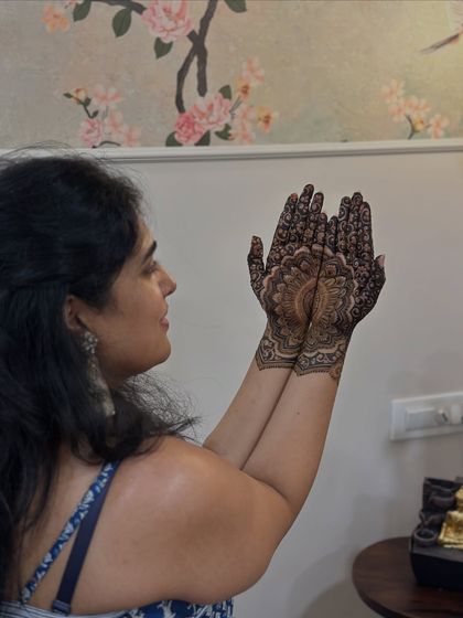 A candid shot of the bride admiring her perfectly symmetrical mandala mehendi.