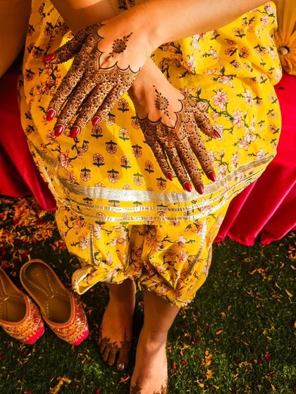 A top-down shot showing how minimal henna on the hands and feet can create a complete and elegant bridal look.