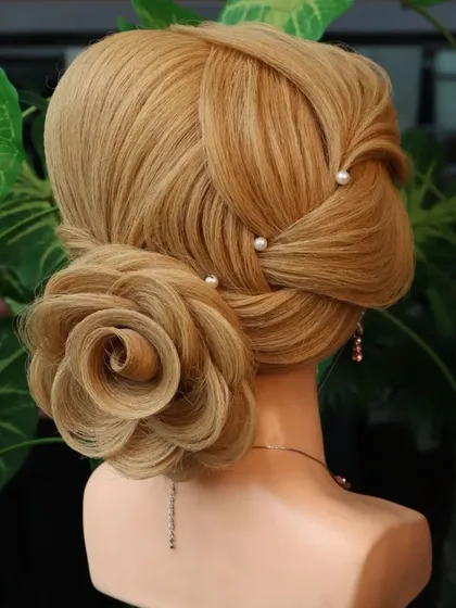 A beautiful rose bun hairstyle with a leaf element. The delicate hair leaf adds a touch of nature-inspired artistry to this romantic and classic updo.