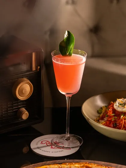 A classic cocktail in a vintage setting. The props, like the old radio, help tell a story and establish a specific mood for the bar.