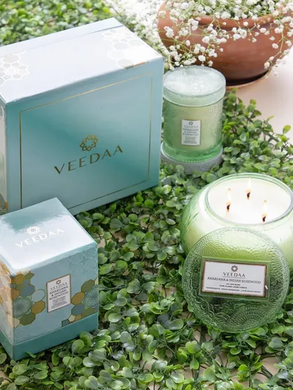 Our candles are made with a blend of globally-sourced, sustainable ingredients. This image showcases our green-themed gift sets, including our popular four-wick candle, perfect for eco-conscious gifting.