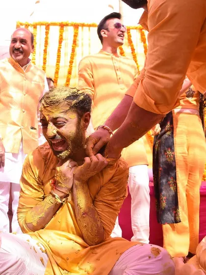 A candid shot of the groom getting playfully covered in haldi by his loved ones. It's moments like these that make the ceremony so memorable.