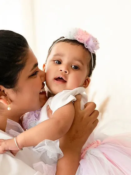 A close-up portrait of a mother holding her baby girl. These shots capture the sweet, affectionate bond between a parent and child.